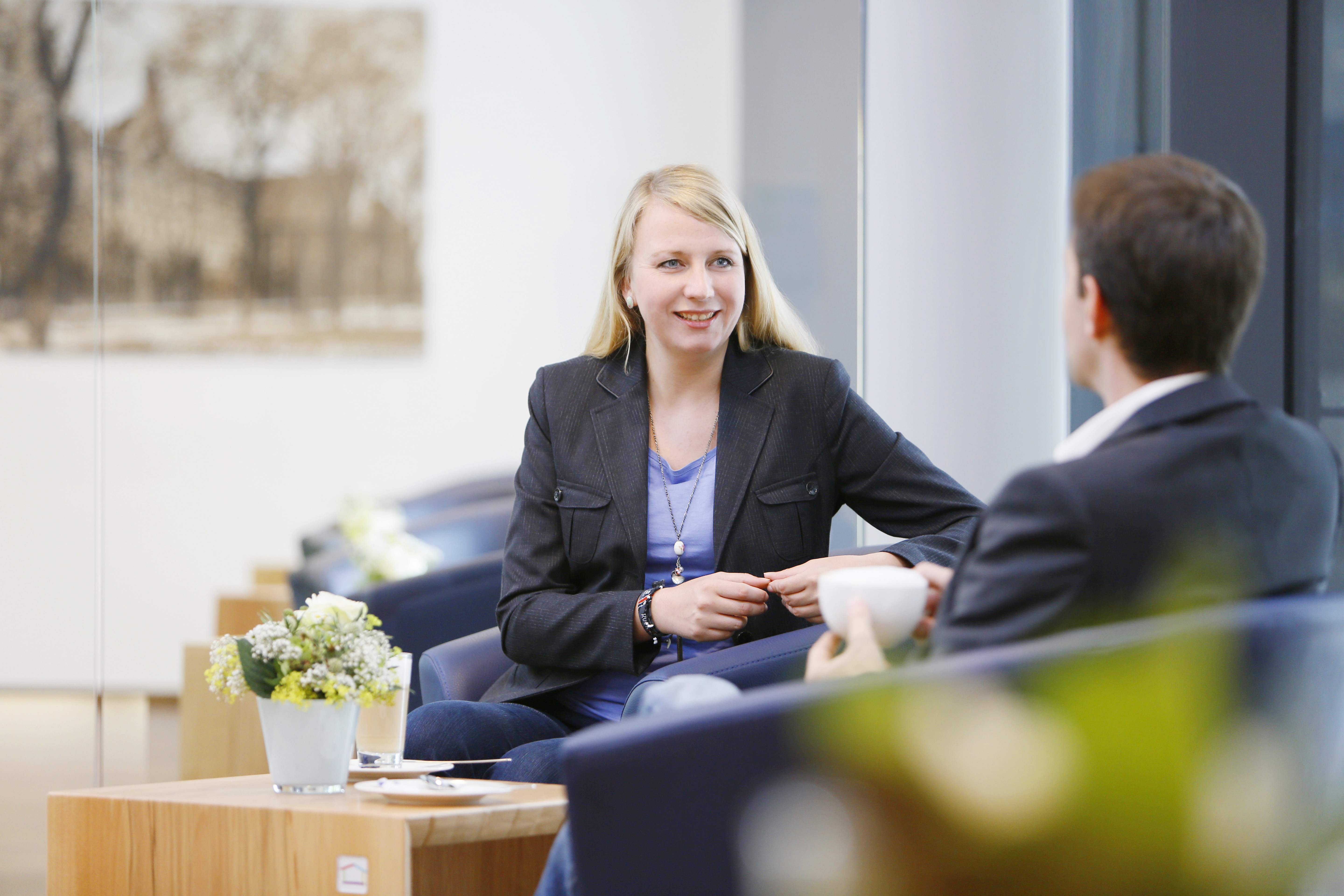 Zwei Personen sitzen in kleinen Sesseln in der Lounge und unterhalten sich