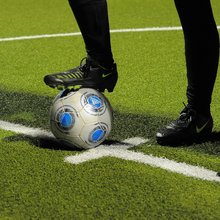 Fuß auf Fußball auf dem Fußballplatz