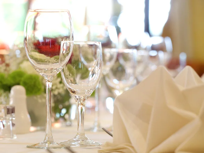 Elegant gedeckter Tisch mit Weingläsern und Blumenarrangement.